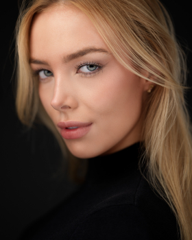Close-up studio portrait of a blonde woman in black by Montreal portrait photographer Vadim Daniel.