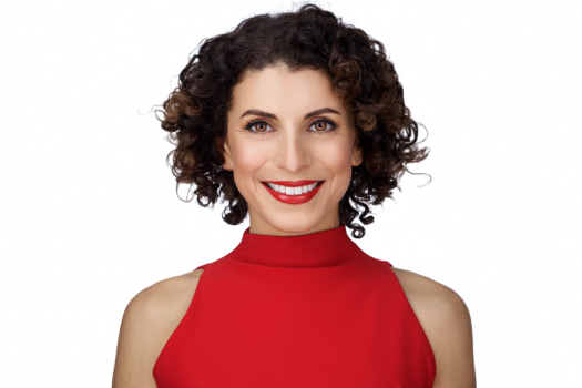 Portrait professionnel d’une femme d’affaires souriante portant une robe rouge, réalisé en studio par le photographe montréalais Vadim Daniel